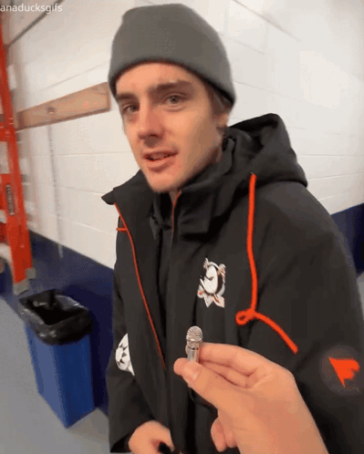 Man in Black Jacket and Grey Beanie Holding Microphone