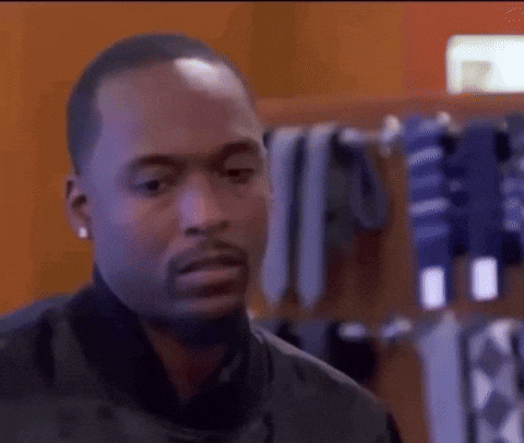 Man in Black Jacket at Rack of Ties