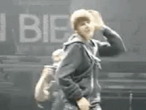 Man in Black Jacket Beside I Bieber Sign