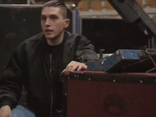 Man in Black Jacket Beside Wooden Box Saying A