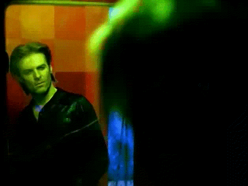 Man in Black Jacket by Red Wall