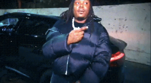 Man In Black Jacket In Front Of Cars GIF