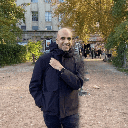 Man in Black Jacket in Front of Paranoia Graffiti