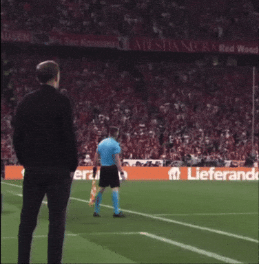 Man in Black Jacket on Soccer Field With Lieferand Banner