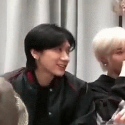 Man in Black Jacket Sitting Next to Woman in White Shirt