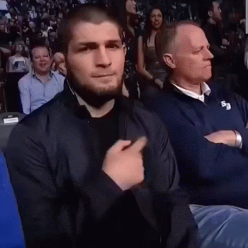 Man in Black Jacket Sitting With Man in Blue Jacket