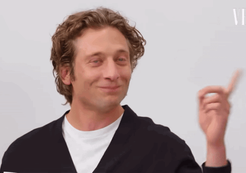 Man In Black Jacket Smiling And Pointing Up GIF