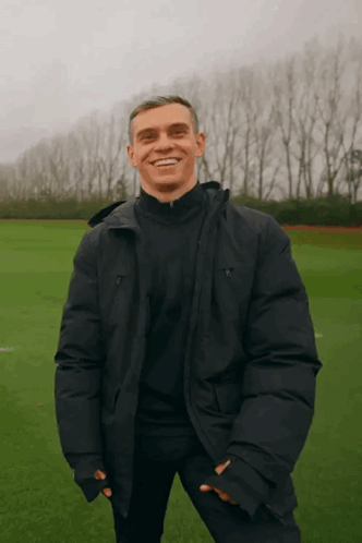 Man in Black Jacket Smiling in Field