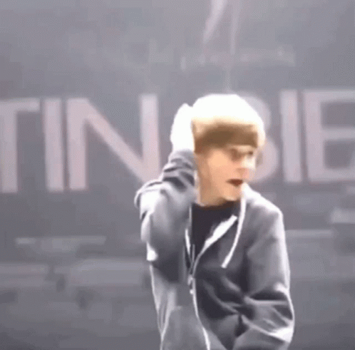 Man In Black Jacket Standing Before Tinibie Sign GIF