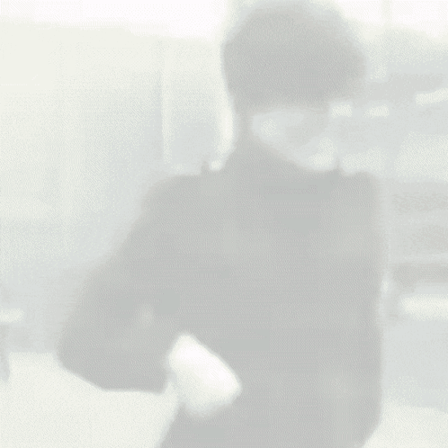 Man In Black Jacket Standing In Front Of Building GIF