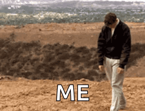 Man in Black Jacket Walking in Dirt Saying Me