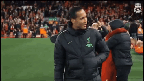 Man in Black Jacket With AXA Walking on Soccer Field