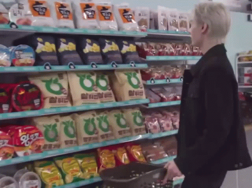 Man In Black Jacket With Basket Of Snacks GIF