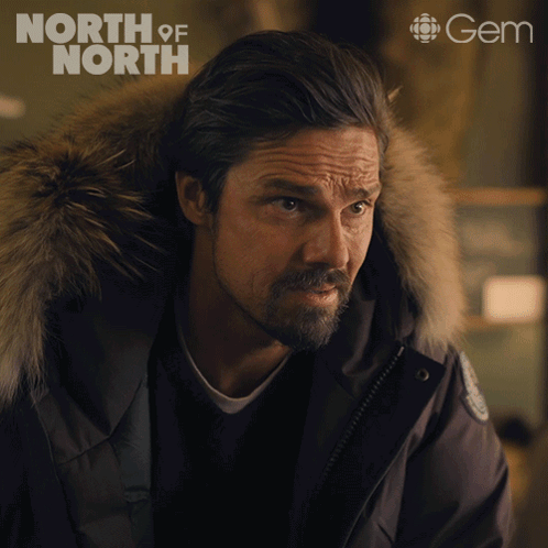 Man in Black Jacket With Fur Hood and Gem Logo