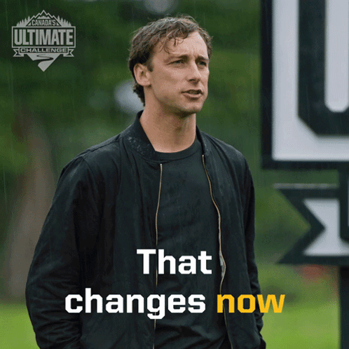 Man in Black Jacket With Sign That Changes Now