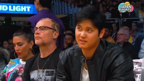 Man in Black Leather Jacket at Basketball Game with Bud Light Sign