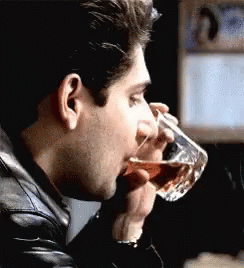 Man In Black Leather Jacket Drinking From Glass GIF