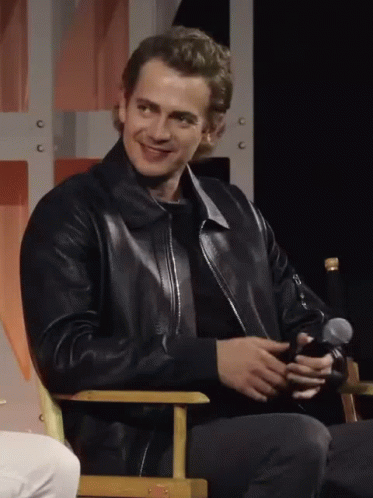 Man In Black Leather Jacket Sitting With Microphone GIF
