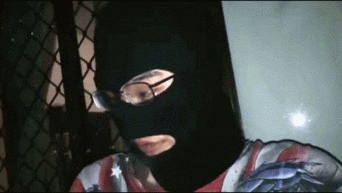 Man In Black Mask And Glasses Looking At Camera GIF