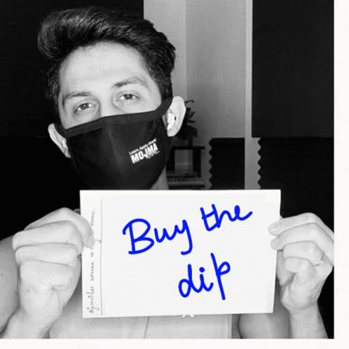 Man In Black Mask Holding Buy The Dip Sign GIF