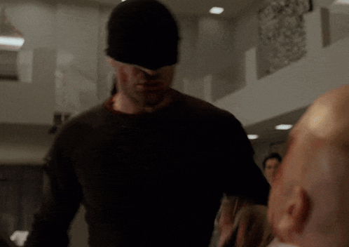 Man in Black Mask Standing Next to Another Man
