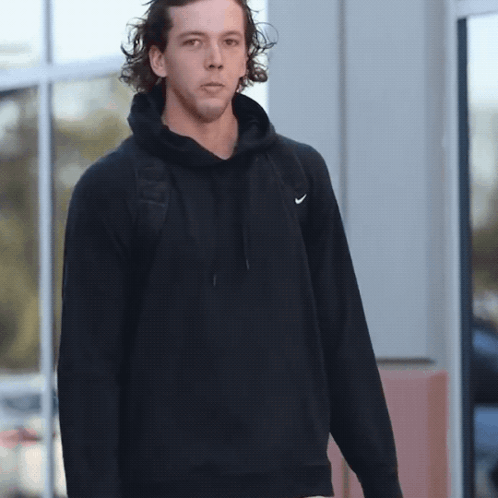 Man in Black Nike Hoodie Standing by Window