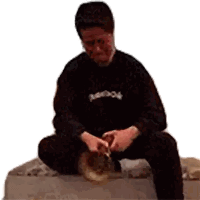 Man in Black Reebok Shirt Sitting on Rock