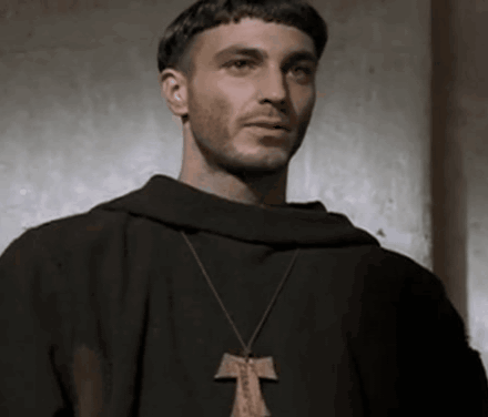 Man in Black Robe and Cross Necklace Looking