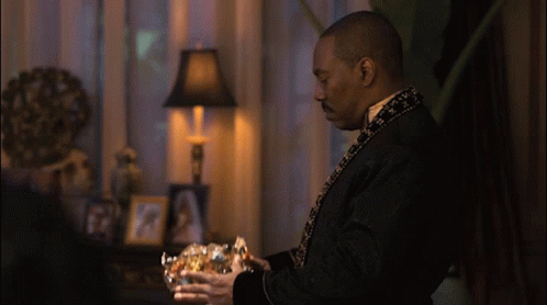Man In Black Robe Holding Gold Bowl GIF