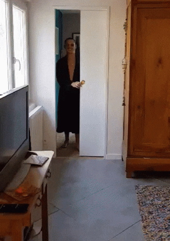 Man in Black Robe Peeking Out of Sliding Door