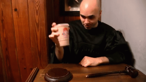 Man in Black Robe Sitting with Cup