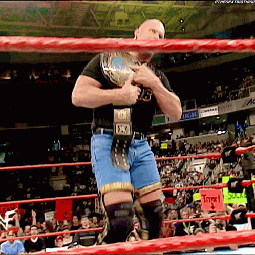 Man In Black Shirt And Blue Shorts Holding Wrestling Belt Number 13 GIF