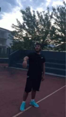 Man in Black Shirt and Blue Shorts on Tennis Court