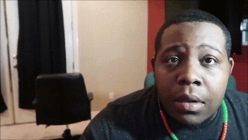 Man in Black Shirt and Green Red Necklace