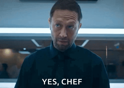 Man in Black Shirt and Tie Saying Yes Chef