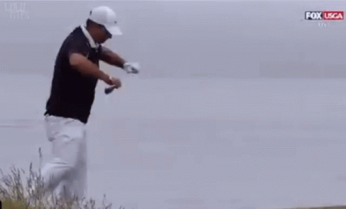 Man In Black Shirt And White Pants Kneeling With Golf Club GIF