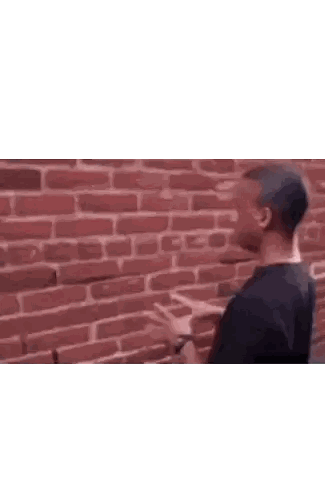 Man in Black Shirt Arms Crossed Brick Wall