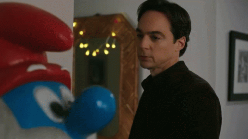 Man in Black Shirt Beside Smurf Statue
