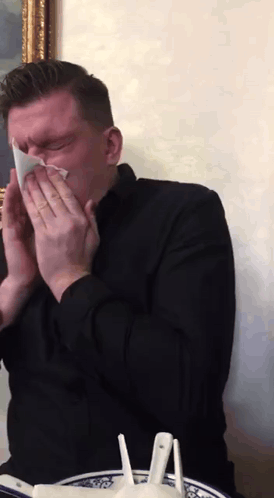 Man in Black Shirt Blowing His Nose