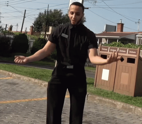 Man in Black Shirt by Trash Can Déchets