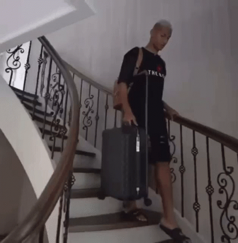 Man in Black Shirt Carrying Suitcase