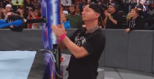 Man in Black Shirt Clapping at Wrestling Match