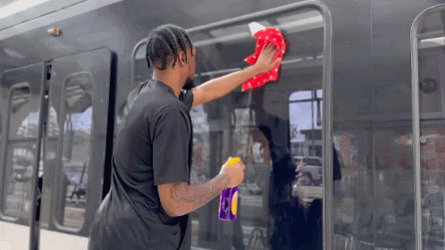 Man in Black Shirt Cleaning Bus With Cloth