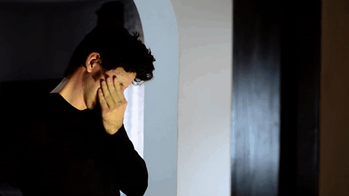 Man in Black Shirt Covering Face