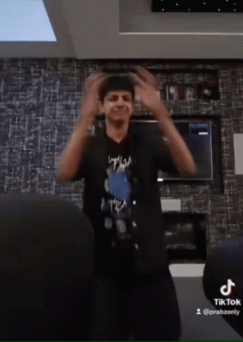Man in Black Shirt Dancing by TikTok Logo