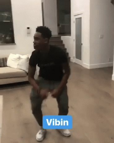 Man in Black Shirt Dancing With Vibin Sign
