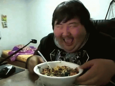 Man in Black Shirt Eating Bowl with Tongue Out