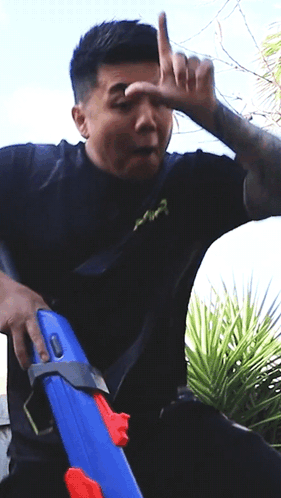 Man in Black Shirt Holding Blue Water Gun