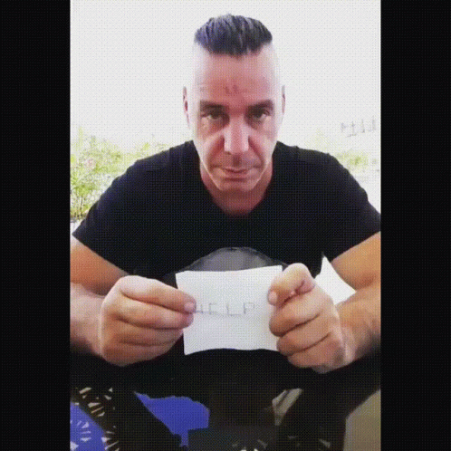 Man in Black Shirt Holding Help Paper