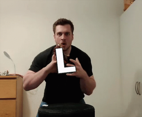 Man In Black Shirt Holding Large L GIF